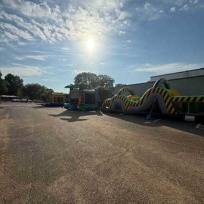 Tropical bounce house and obstacle course set up on pavement