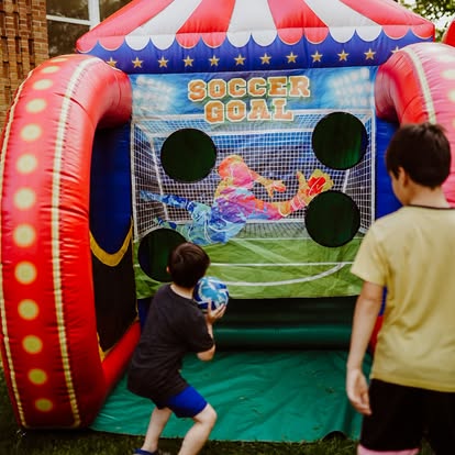 Kids playing an inflatable soccer goal game